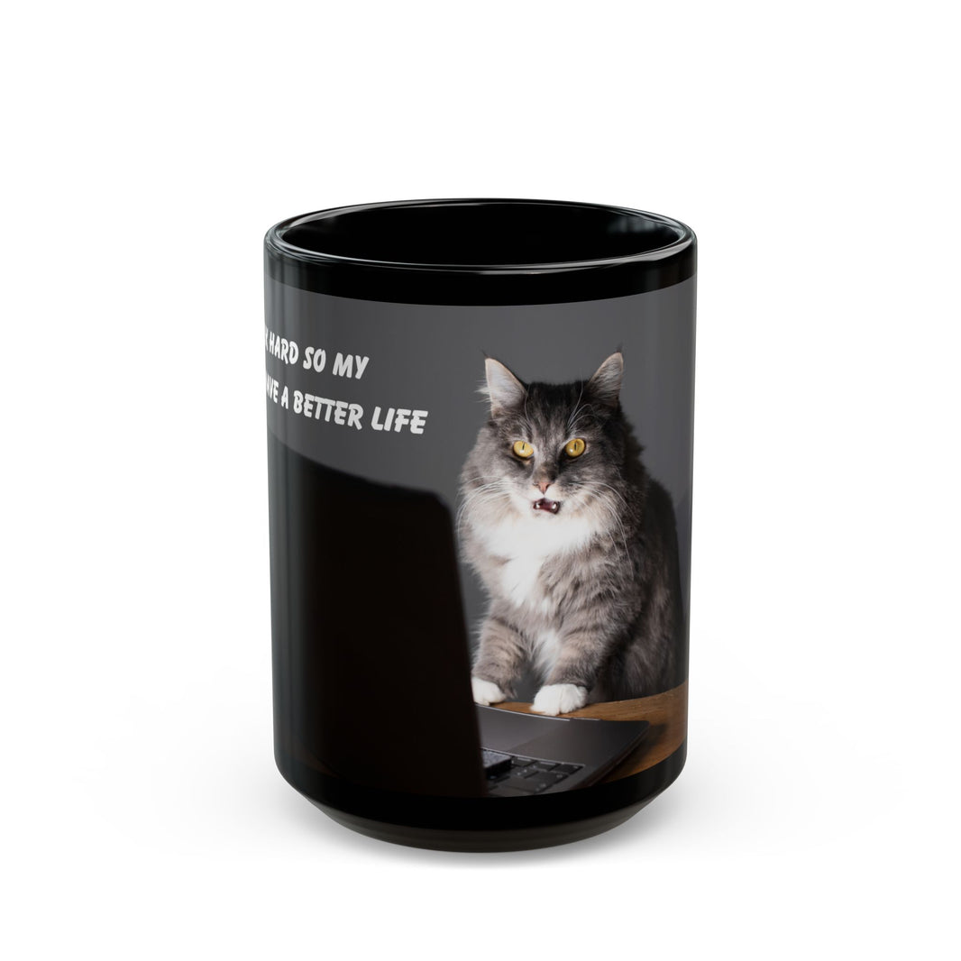 Black ceramic mug featuring a cartoon-style image of a cat sitting at a computer with the funny quote “I work hard so my cat can have a better life.”