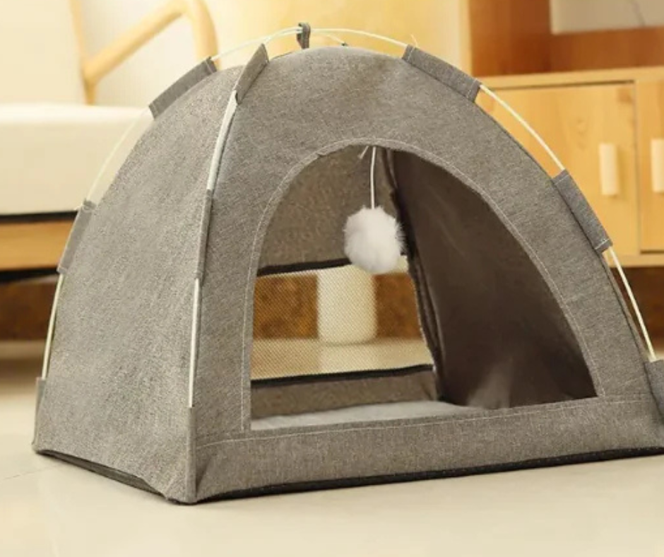 Gray pet tent with a fluffy white ball inside on a light-colored floor.