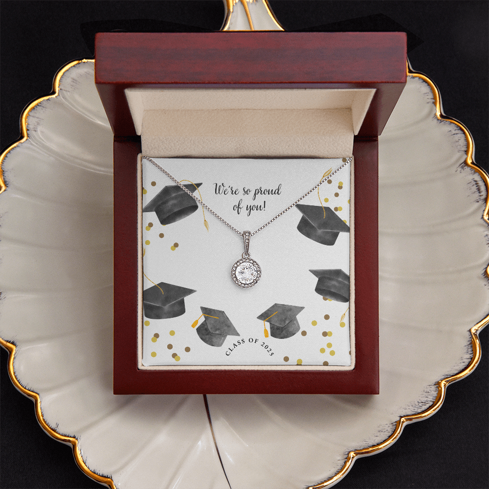 Open gift box displaying a sparkling silver Eternal Hope necklace with a round pendant, set against a graduation-themed message card that reads "We're so proud of you!" with graduation caps, gold confetti, and "Class of 2025" text.
