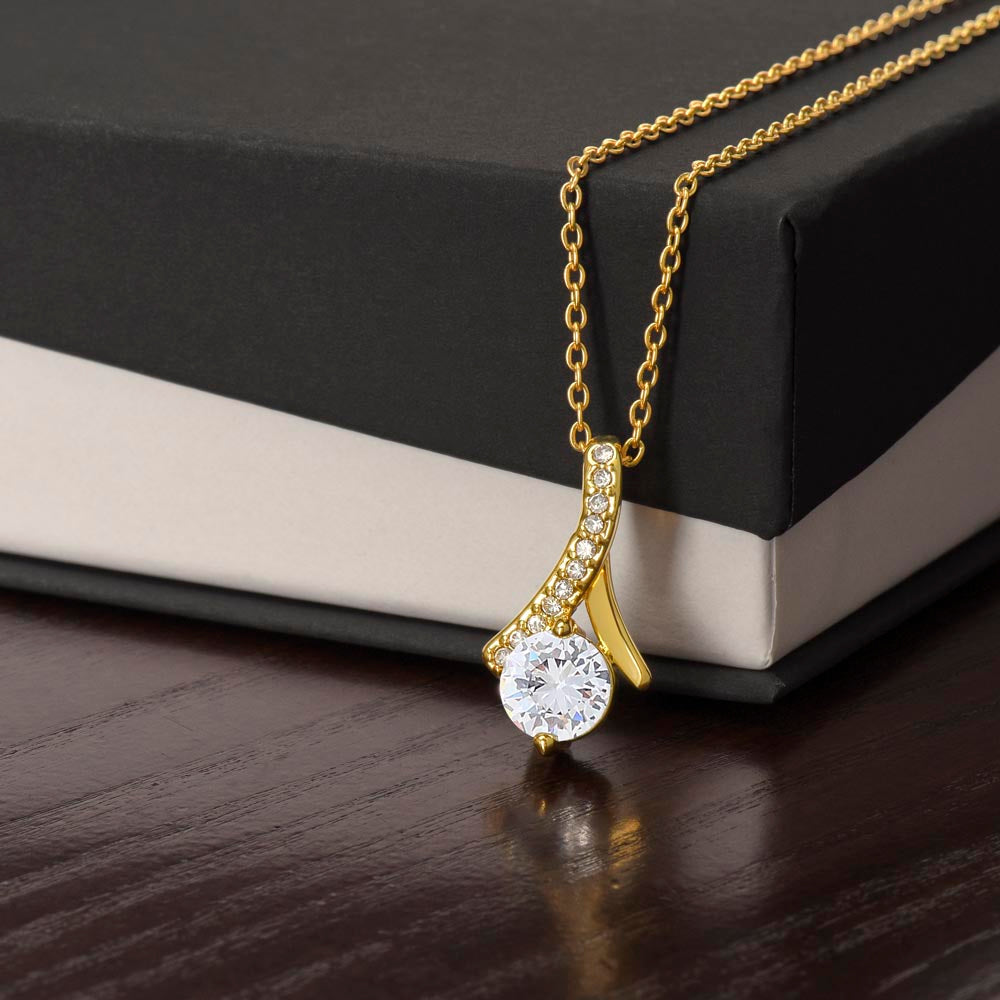 Alluring Beauty necklace features a petite ribbon shaped pendant.. 18k yellow gold finish