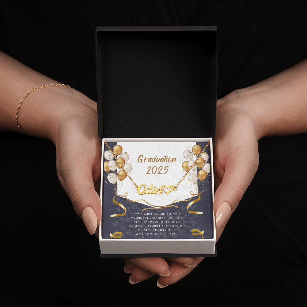 Close-up of hands holding a
personalized gold name necklace with heart, set against a message card that reads "Graduation 2025" and includes an inspiring graduation quote, with gold and white balloons in the background.