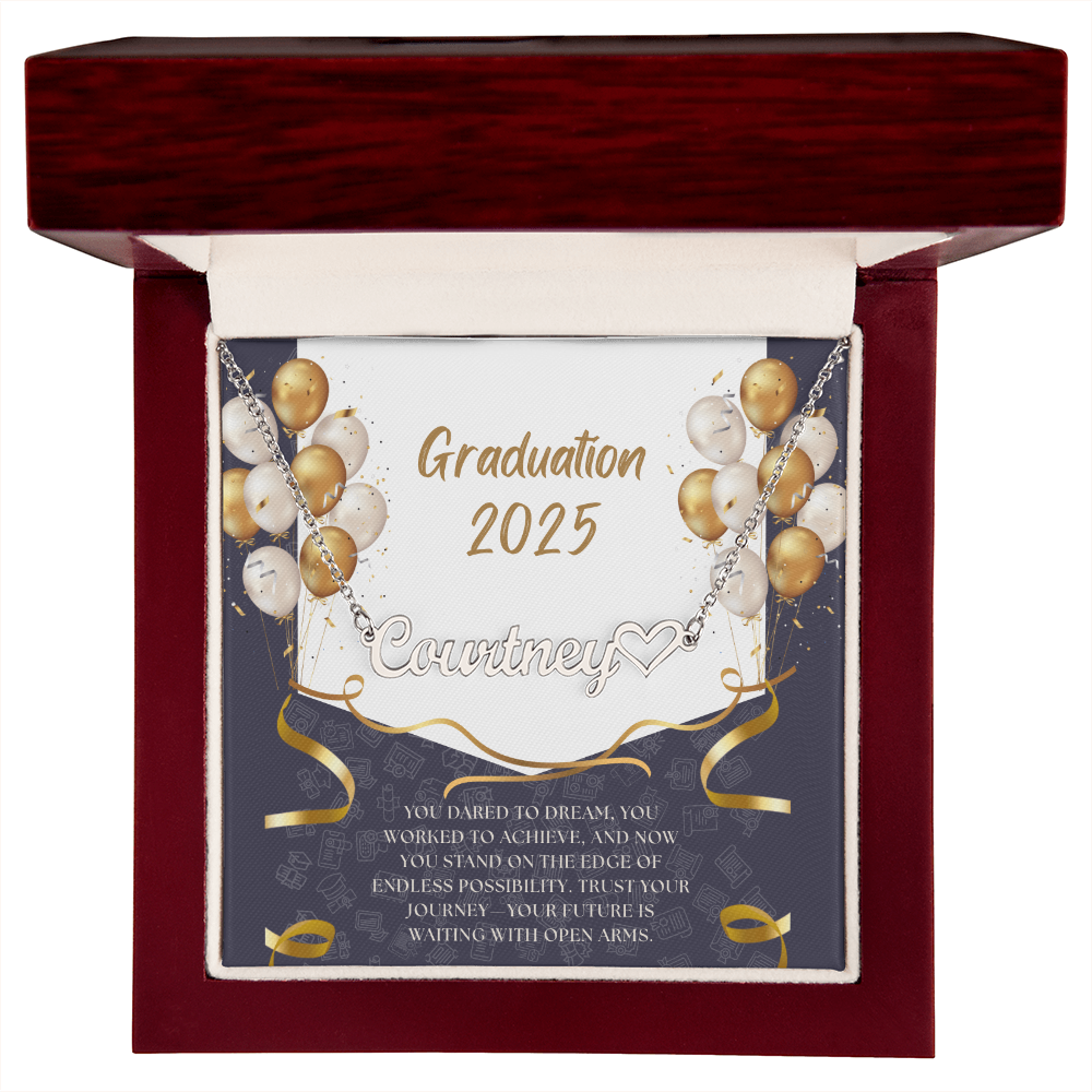 Close-up of hands holding an open red gift box featuring a personalized silver name necklace with heart, set against a message card that reads "Graduation 2025" and includes an inspiring graduation quote, with gold and white balloons in the background.