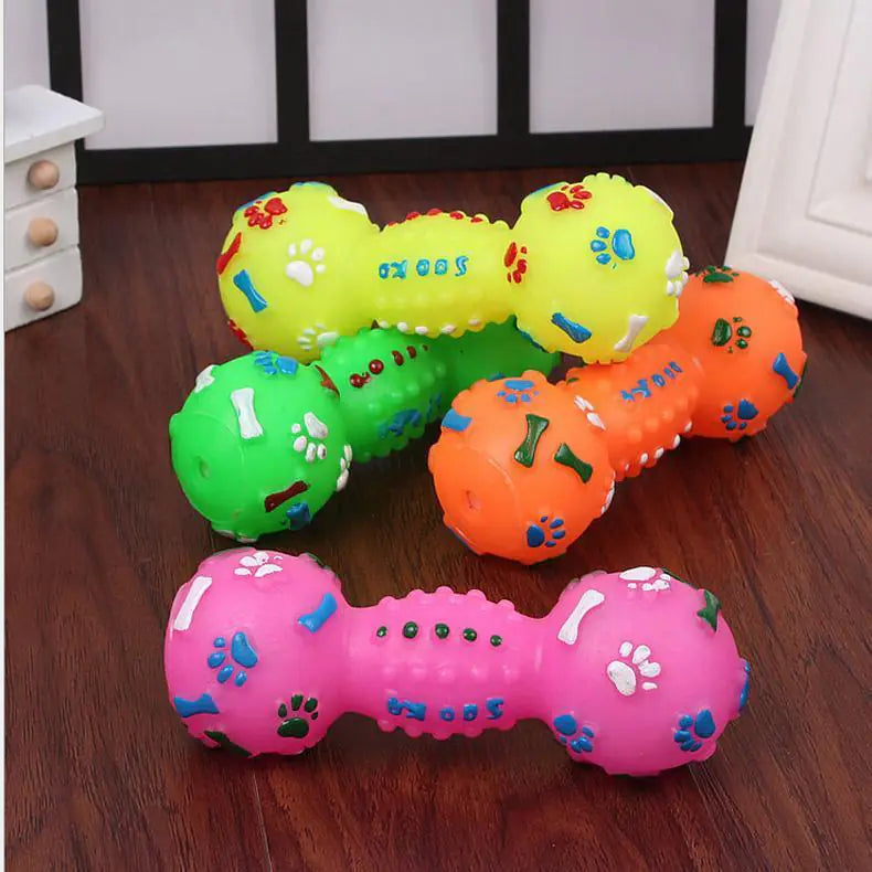 Colorful dog toys shaped like dumbbells on a wooden floor.