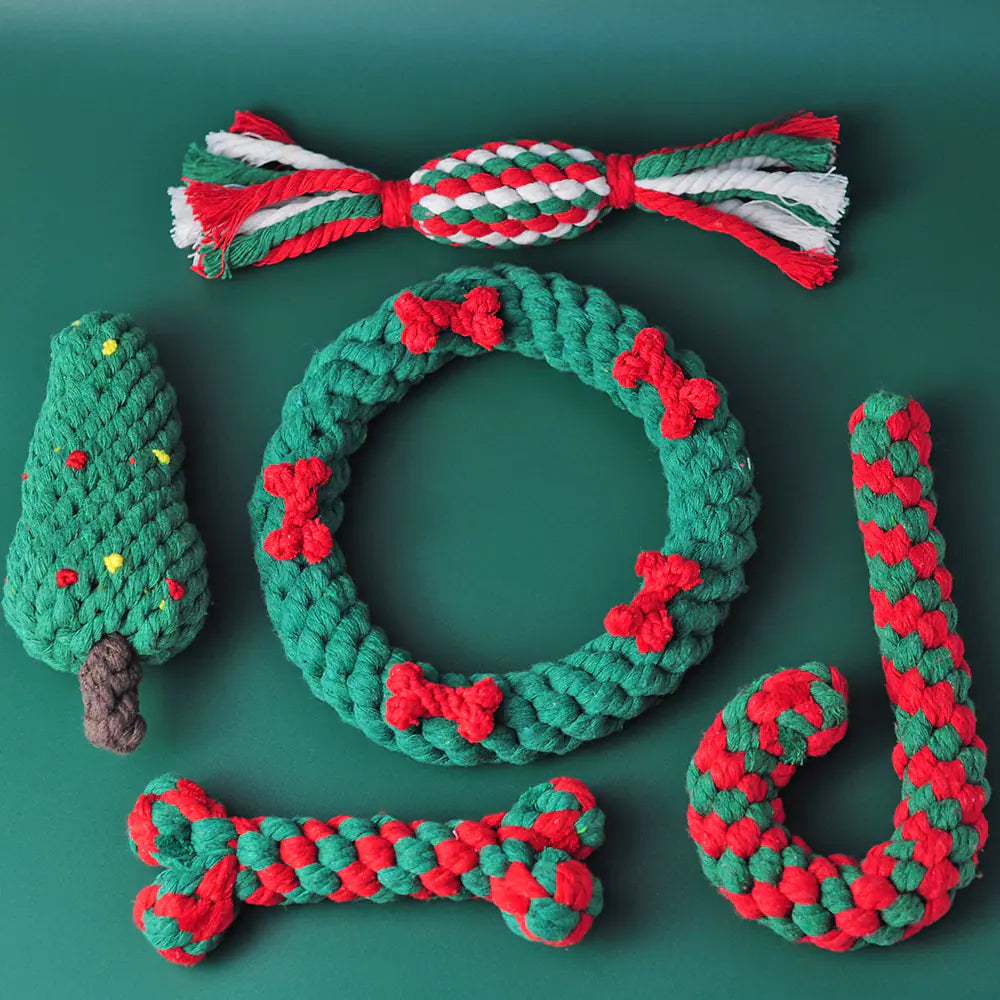 Set of Christmas-themed dog toys including a wreath, candy cane, and tree on a green background
