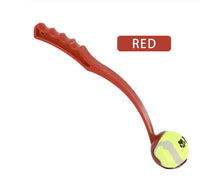 Red dog toy with a tennis ball attached on a white background
