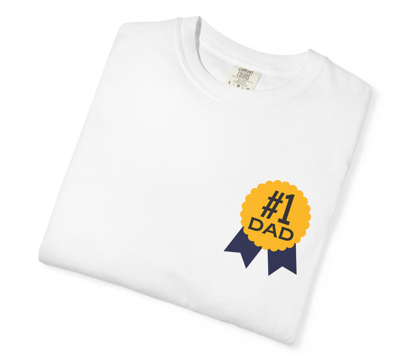 White t-shirt featuring a yellow and navy blue award ribbon graphic on the chest with the text "#1 Dad," designed as a fun and heartfelt Father's Day gift.