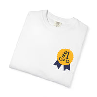 White t-shirt featuring a yellow and navy blue award ribbon graphic on the chest with the text "#1 Dad," designed as a fun and heartfelt Father's Day gift.