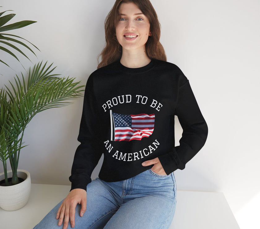 Person wearing a black sweatshirt with 'Proud to be an American' text and flag design, sitting on a white surface with a plant in the background.