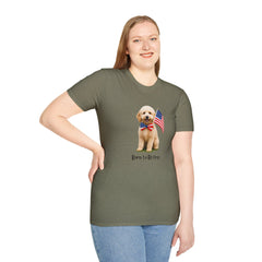 Female wearing T-shirt featuring a cute golden doodle puppy wearing an American flag bow tie and holding a small U.S. flag, with the phrase 'Born to Be Free' printed below the image.