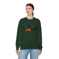 Person wearing a green sweatshirt with black cats and pumpkins design on a white background