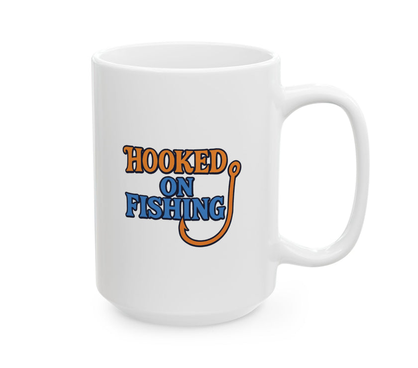 A white ceramic coffee mug displayed against a plain background, featuring the phrase "Hooked on Fishing" in bold orange and blue text with a graphic of a fishing hook integrated into the design.