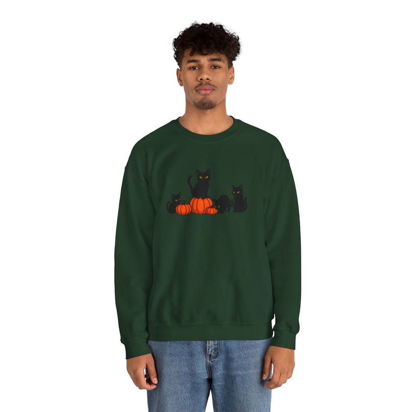 Person wearing a green sweatshirt with black cats and pumpkins design on a white background