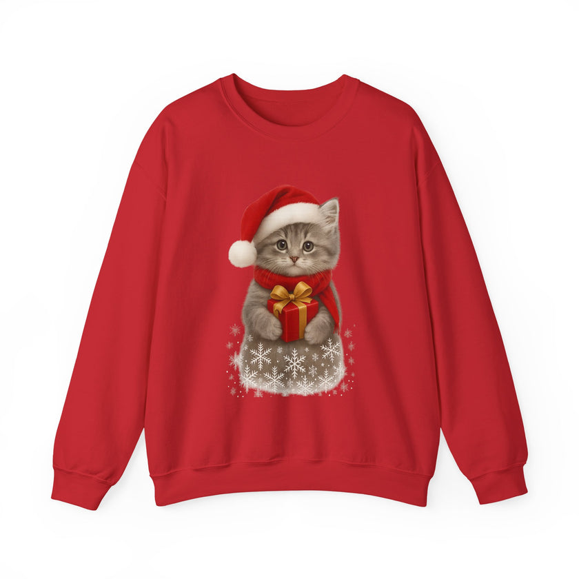 Red sweatshirt featuring a gray kitten wearing a Santa hat and red scarf, holding a small red gift box with a gold bow, surrounded by snowflake designs.