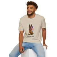 Beige t-shirt featuring a patriotic German Shepherd wearing an American flag bowtie and holding U.S. flags, with the phrase "Born to Be Free" printed below — perfect for dog lovers and patriotic Americans.