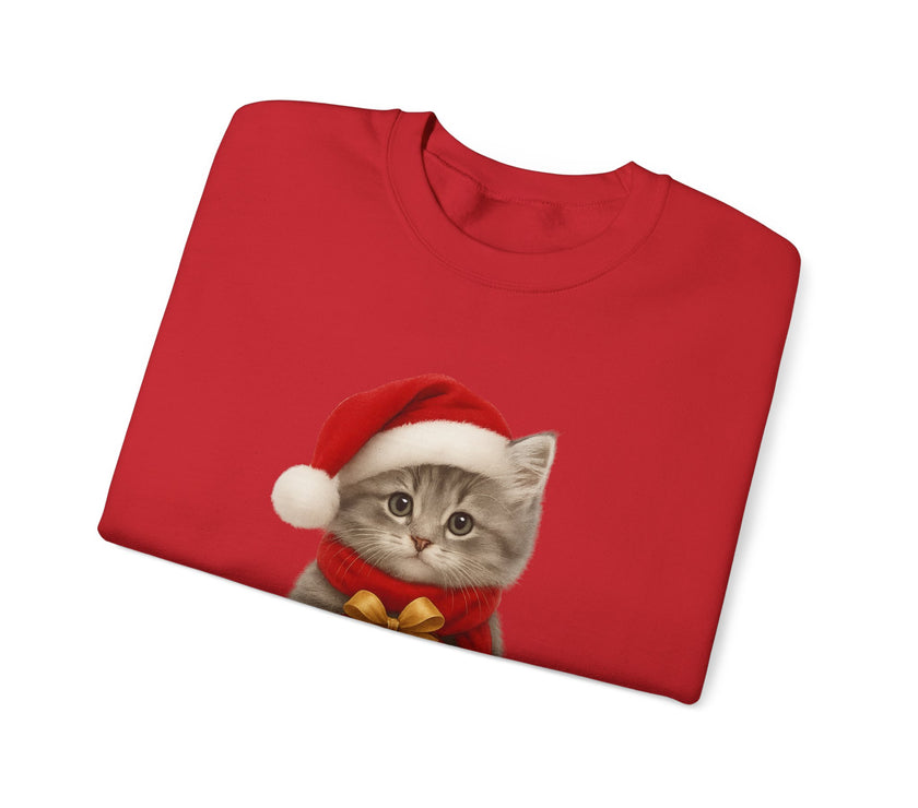 Red folded sweatshirt featuring a gray kitten wearing a Santa hat and red scarf, holding a small red gift box with a gold bow, surrounded by snowflake designs.