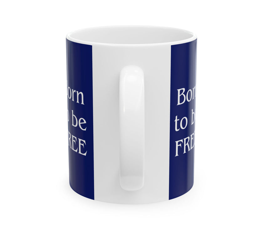 A ceramic mug featuring aGoldendoodle sitting on grass, wearing a red, white, and blue bow tie, and holding an American flag against a dark blue background. with the message "Born to be Free"