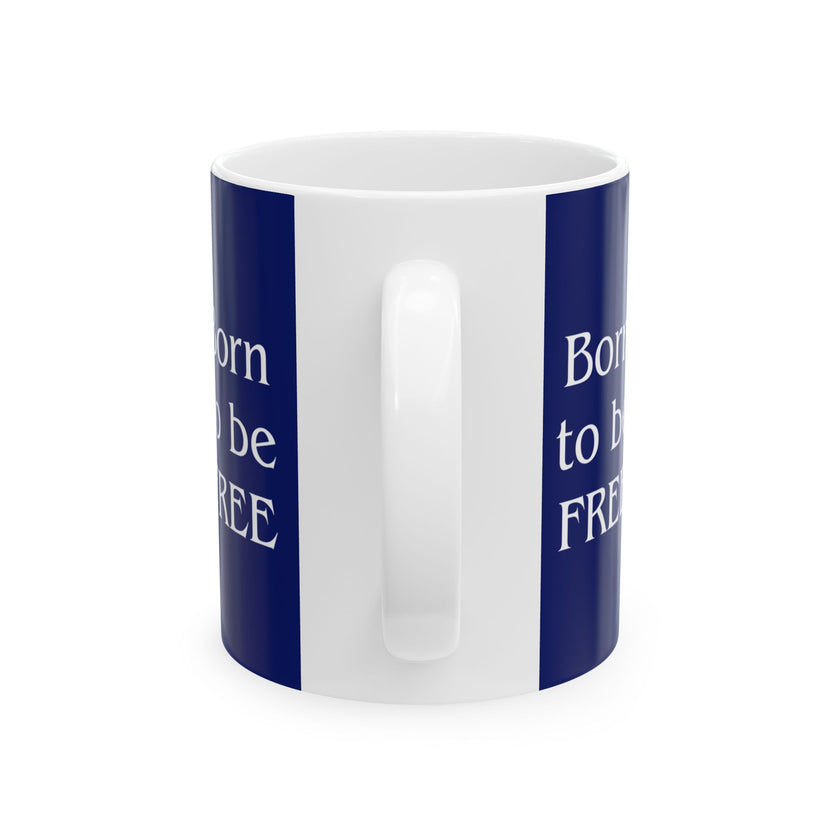 A ceramic mug featuring aGoldendoodle sitting on grass, wearing a red, white, and blue bow tie, and holding an American flag against a dark blue background. with the message "Born to be Free"