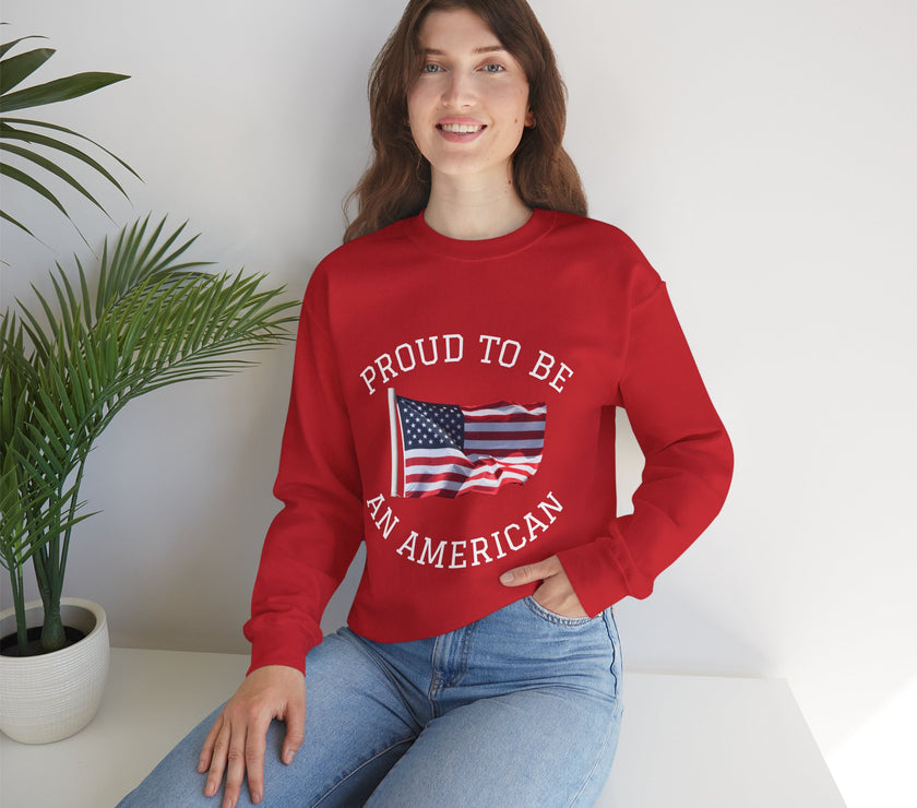 Person wearing a red sweatshirt with 'Proud to be an American' text and flag design, sitting on a white surface with a plant in the background.