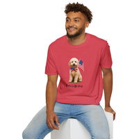 Male wearing T-shirt featuring a cute golden doodle puppy wearing an American flag bow tie and holding a small U.S. flag, with the phrase 'Born to Be Free' printed below the image.