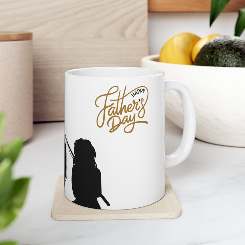 White ceramic mug featuring a silhouette of a child holding a fishing rod next to an adult figure, with the words "Happy Father's Day" in gold script above—an ideal gift for dads who love fishing and family time.