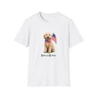 White t-shirt featuring a cute golden doodle puppy wearing an American flag bow tie and holding a small U.S. flag, with the phrase 'Born to Be Free' printed below the image.
