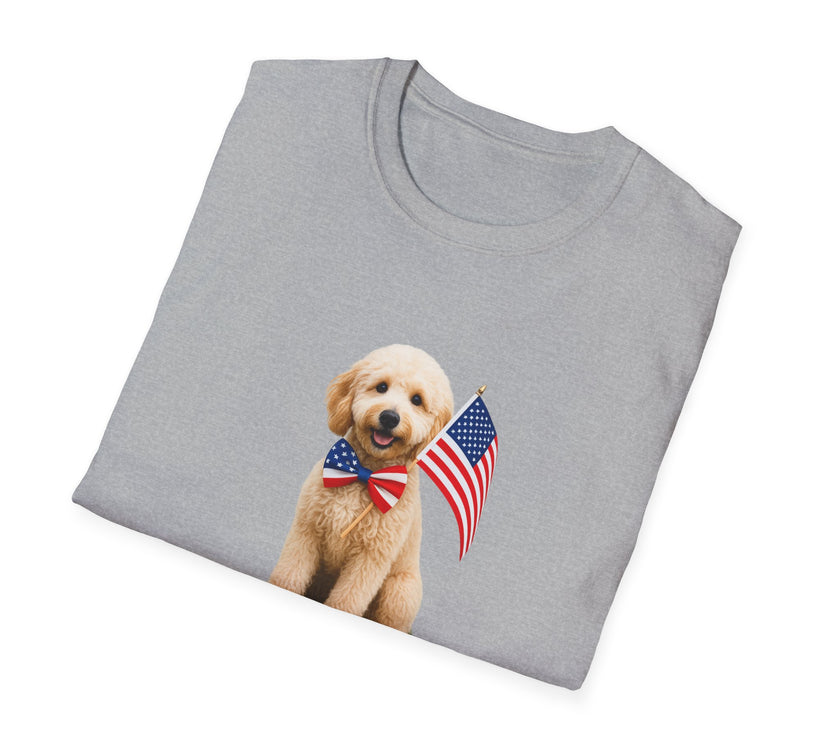 T-shirt featuring a cute golden doodle puppy wearing an American flag bow tie and holding a small U.S. flag, with the phrase 'Born to Be Free' printed below the image.  Folded