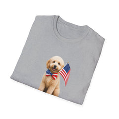T-shirt featuring a cute golden doodle puppy wearing an American flag bow tie and holding a small U.S. flag, with the phrase 'Born to Be Free' printed below the image.  Folded