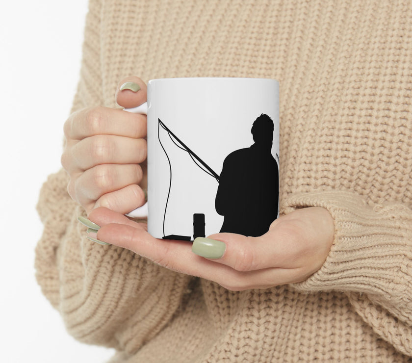 White ceramic mug featuring a silhouette of a child holding a fishing rod next to an adult figure, with the words "Happy Father's Day" in gold script above—an ideal gift for dads who love fishing and family time.