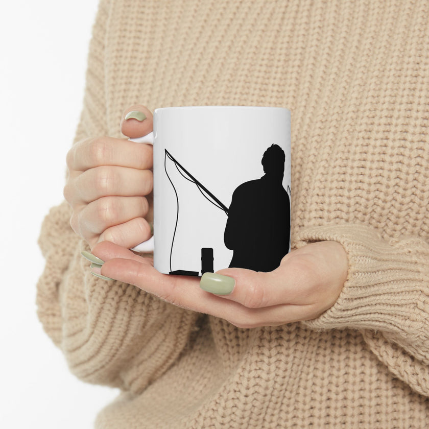 White ceramic mug featuring a silhouette of a child holding a fishing rod next to an adult figure, with the words "Happy Father's Day" in gold script above—an ideal gift for dads who love fishing and family time.