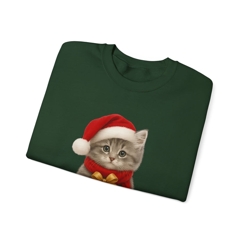 Green folded sweatshirt featuring a gray kitten wearing a Santa hat and red scarf, holding a small red gift box with a gold bow, surrounded by snowflake designs.