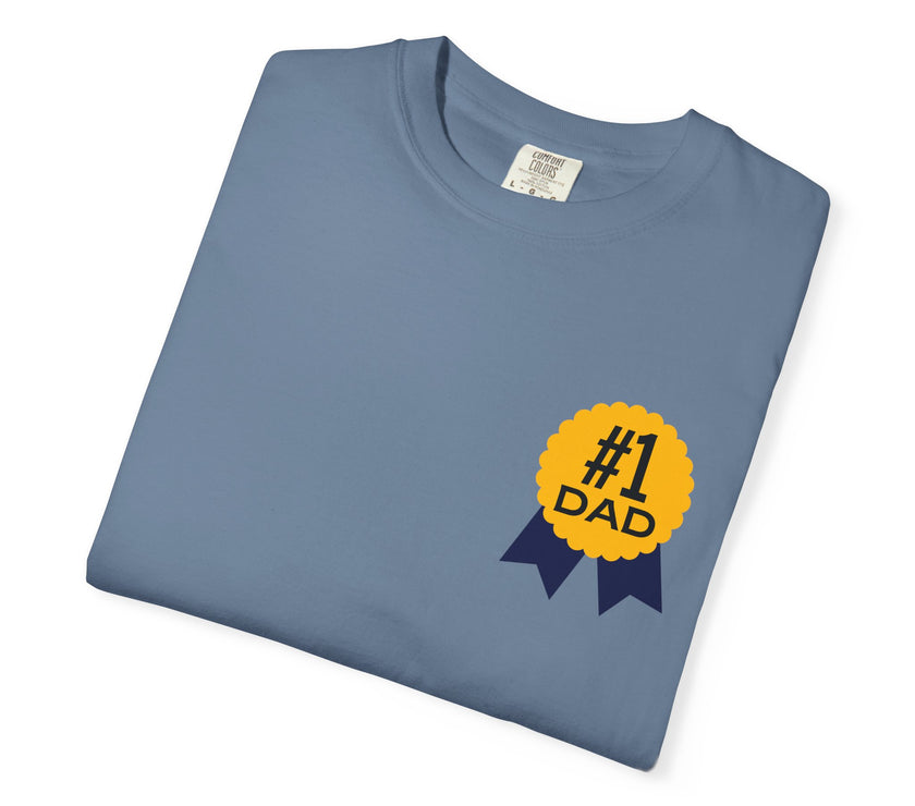 Jean color t-shirt featuring a yellow and navy blue award ribbon graphic on the chest with the text "#1 Dad," designed as a fun and heartfelt Father's Day gift.