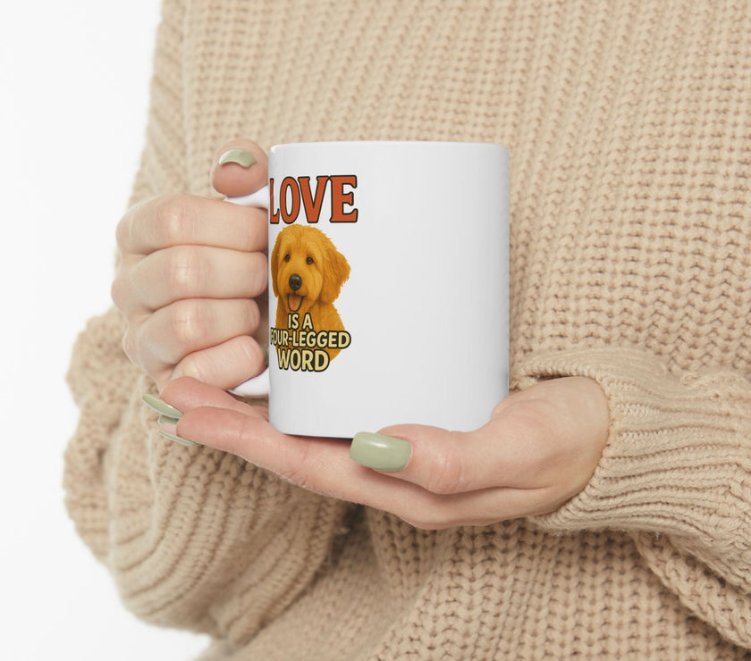 Person holding a mug with a dog illustration and text 'LOVE is a four-legged word' against a beige background
