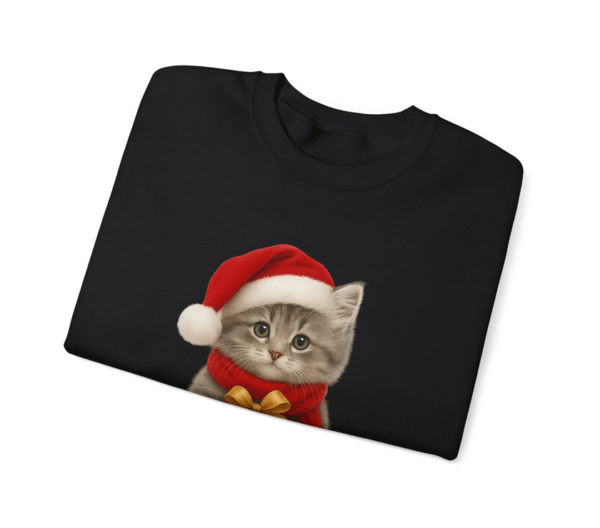 Folded black sweatshirt featuring a gray kitten wearing a Santa hat and red scarf, holding a small red gift box with a gold bow, surrounded by snowflake designs.
