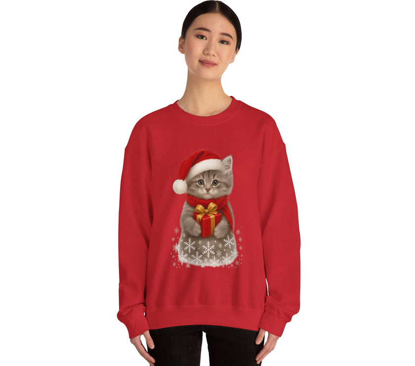 Red sweatshirt featuring a gray kitten wearing a Santa hat and red scarf, holding a small red gift box with a gold bow, surrounded by snowflake designs.