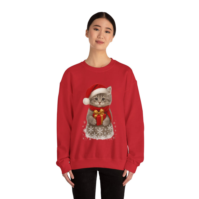 Red sweatshirt featuring a gray kitten wearing a Santa hat and red scarf, holding a small red gift box with a gold bow, surrounded by snowflake designs.