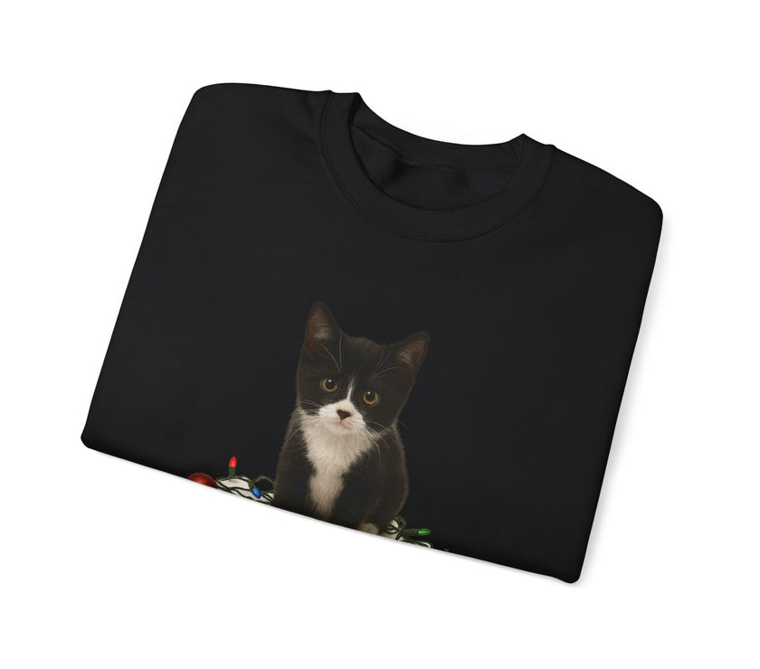 Folded black sweatshirt with a cat graphic on a white background