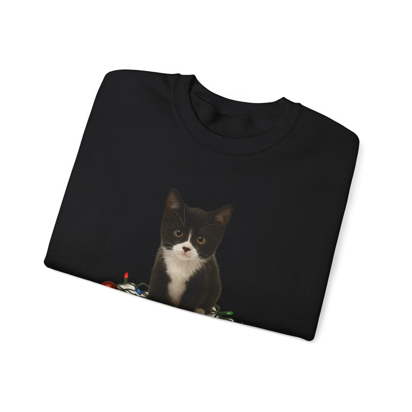 Folded black sweatshirt with a cat graphic on a white background