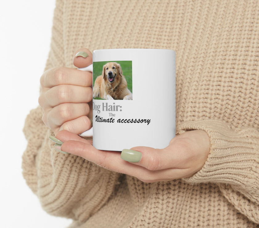 White ceramic mug featuring a photo of a smiling golden retriever lying on grass, with the humorous quote "Dog Hair: The Ultimate Accessory" printed below the image.