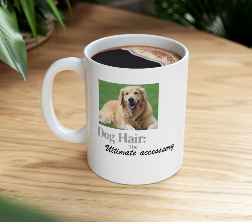 White ceramic mug featuring a photo of a smiling golden retriever lying on grass, with the humorous quote "Dog Hair: The Ultimate Accessory" printed below the image.