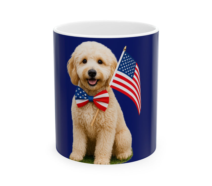 A ceramic mug featuring aGoldendoodle sitting on grass, wearing a red, white, and blue bow tie, and holding an American flag against a dark blue background. with the message "Born to be Free"