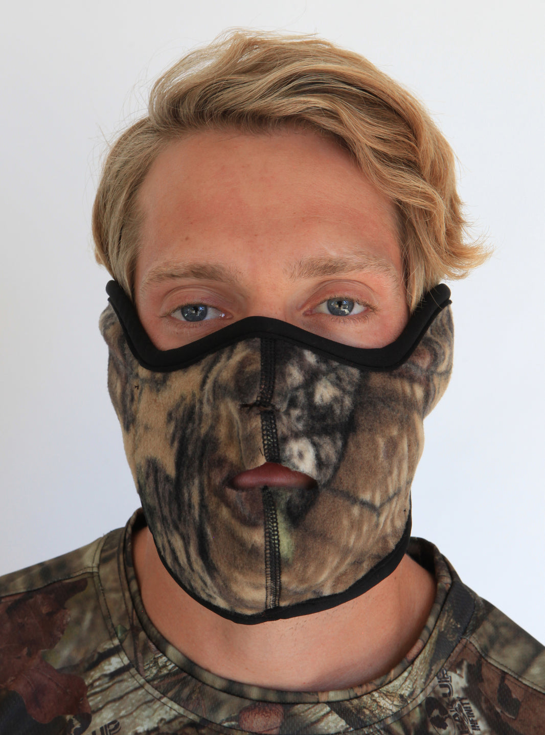 Person wearing a camouflage balaclava with a white background