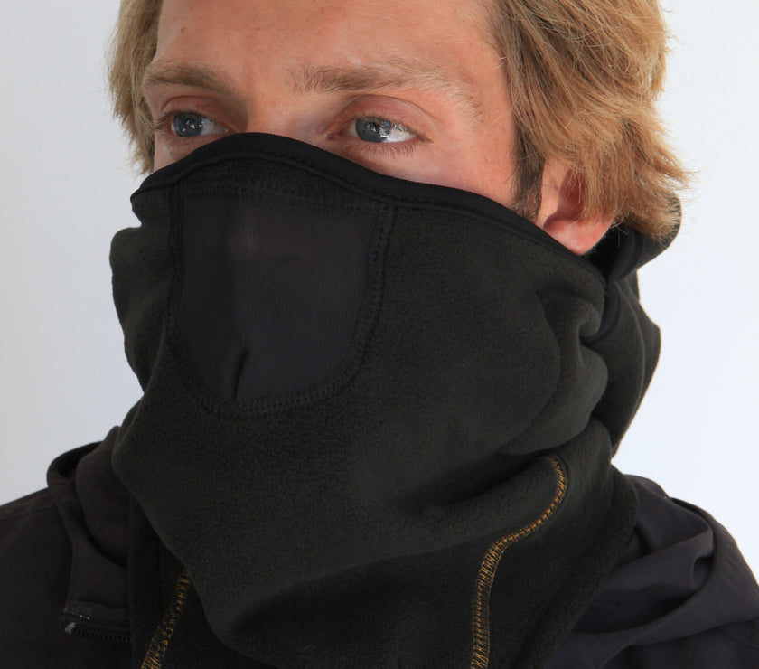 Person wearing a full-face black fleece balaclava with pockets for disposable air-activated warmers on a white background