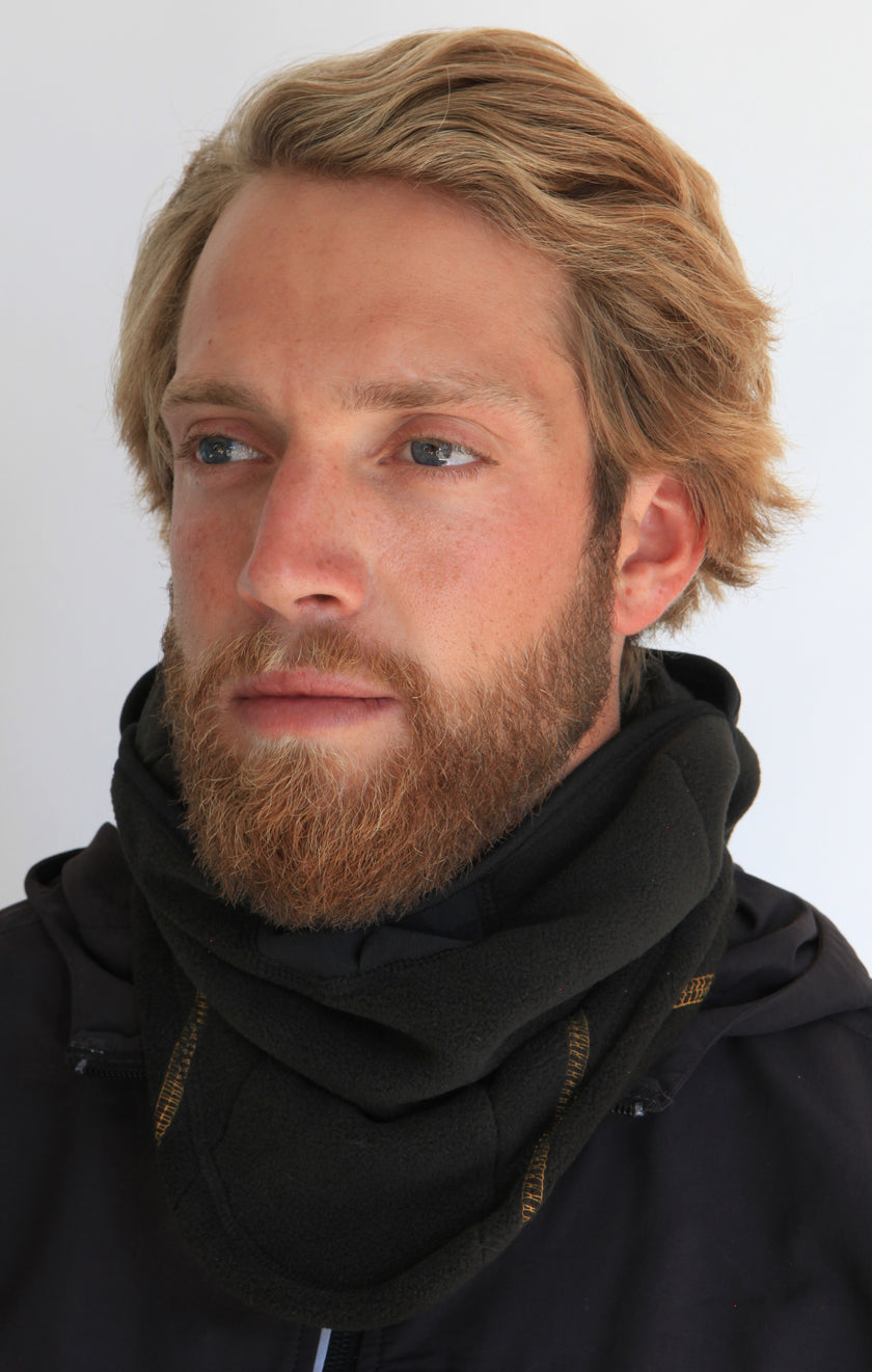 Person wearing a full-face black fleece balaclava with pockets for disposable air-activated warmers on a white background