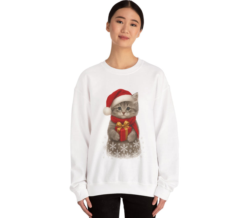 White sweatshirt featuring a gray kitten wearing a Santa hat and red scarf, holding a small red gift box with a gold bow, surrounded by snowflake designs.