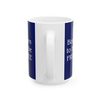 A ceramic mug featuring a Rottweiler sitting on grass, wearing a red, white, and blue bow tie, and holding an American flag against a dark blue background. with the message "Born to be Free"