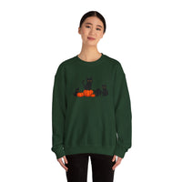Person wearing a green sweatshirt with black cats and pumpkins design on a white background