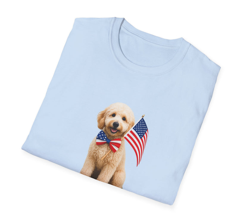 Folded T-shirt featuring a cute golden doodle puppy wearing an American flag bow tie and holding a small U.S. flag, with the phrase 'Born to Be Free' printed below the image.
