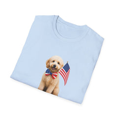 Folded T-shirt featuring a cute golden doodle puppy wearing an American flag bow tie and holding a small U.S. flag, with the phrase 'Born to Be Free' printed below the image.