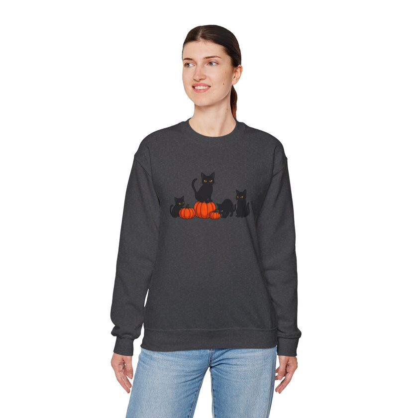 Person wearing a dark gray sweatshirt with black cat and orange pumpkin design on a white background