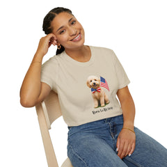Female wearing T-shirt featuring a cute golden doodle puppy wearing an American flag bow tie and holding a small U.S. flag, with the phrase 'Born to Be Free' printed below the image.